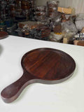Non-stick pizza pan with handle on a countertop with a freshly baked pizza

